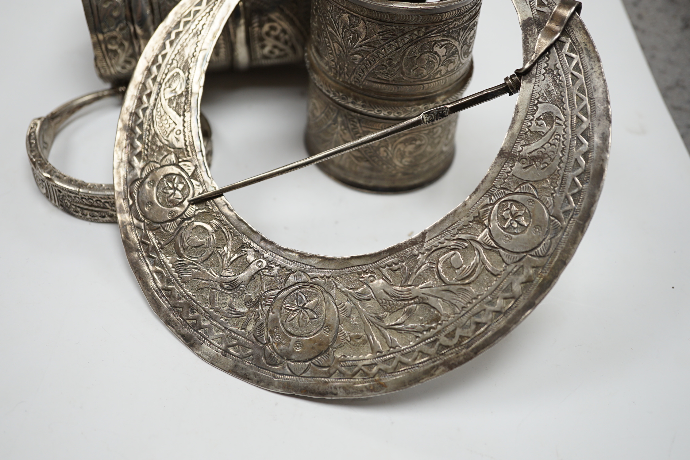 A collection of eight North African Berber white metal jewellery, etc, including bangles, cuffs and hair ornament.